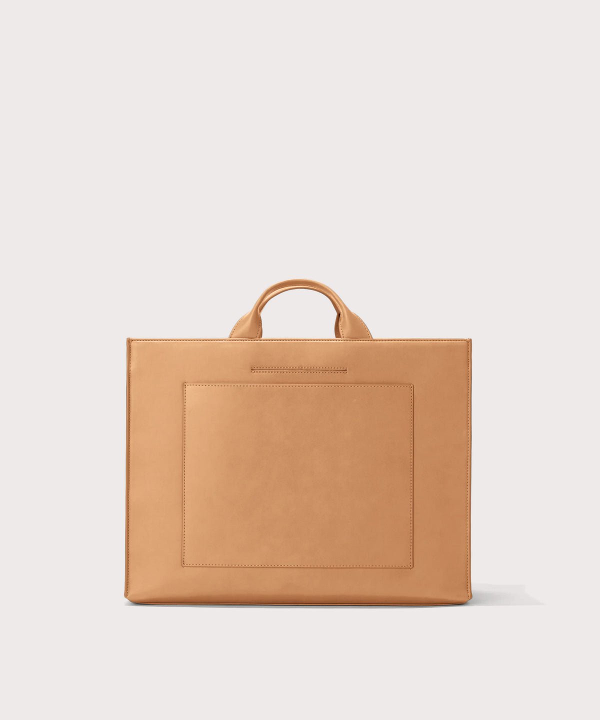 Dagne Dover large vegan Daily Tote in brown revealing the exterior phone pocket and exterior luggage sleeve.