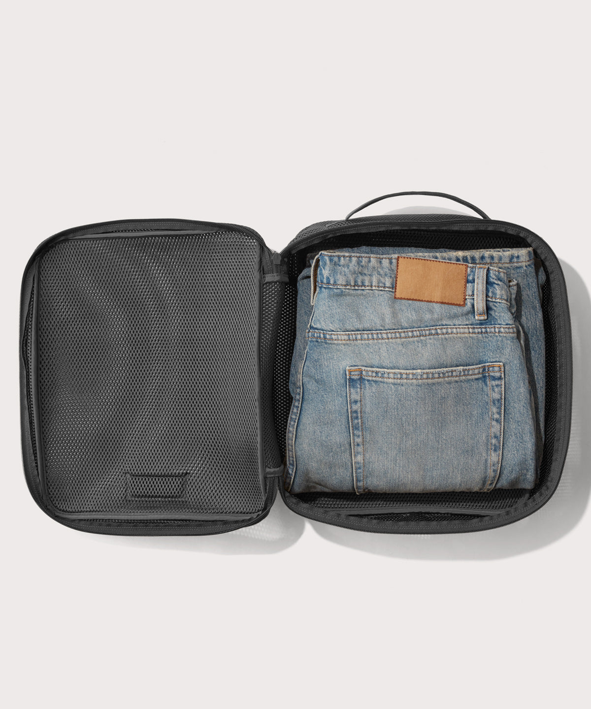 Large Roma packing cube in carbon black open with jeans inside
