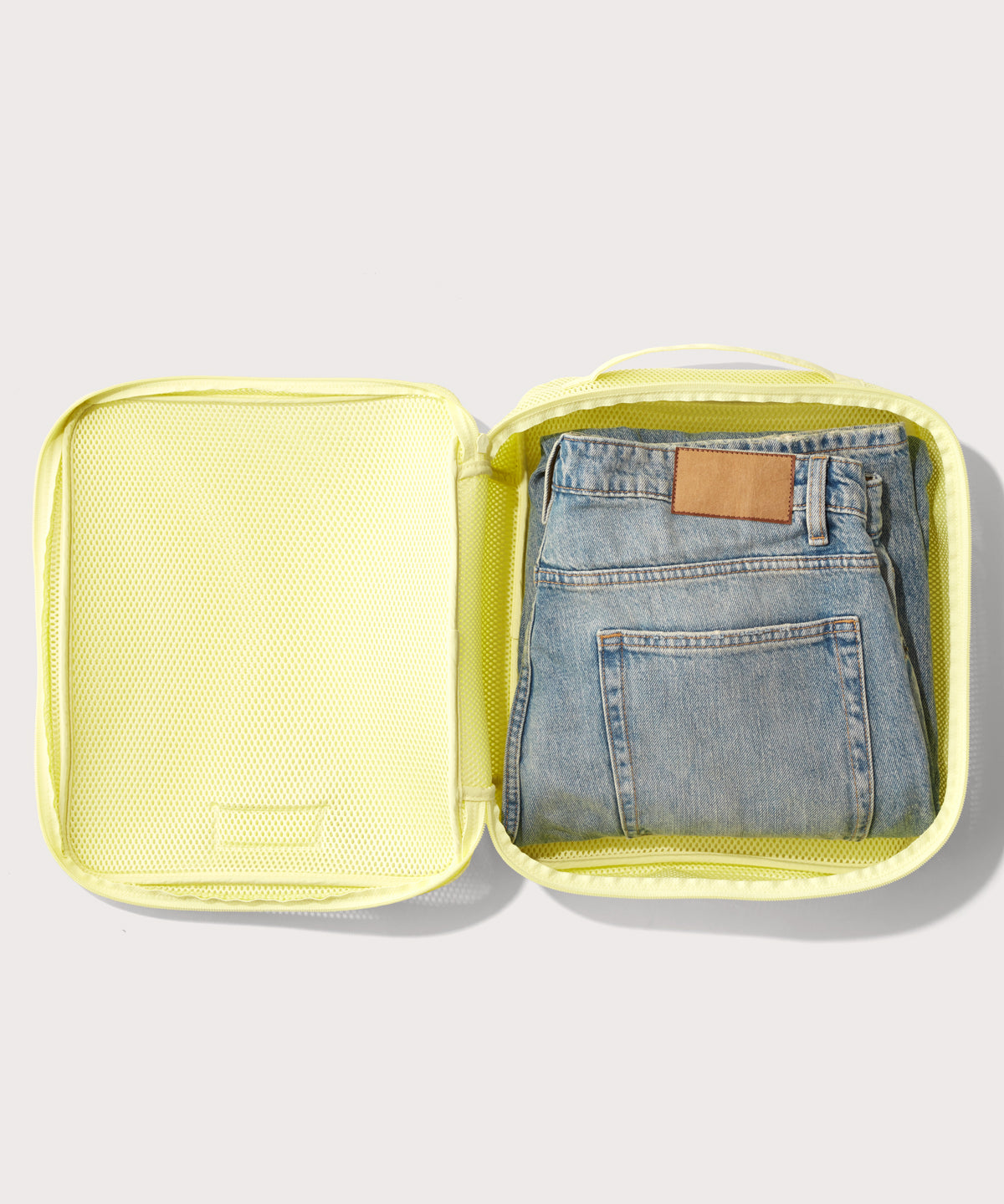 Large Roma packing cube in citrine open with jeans inside
