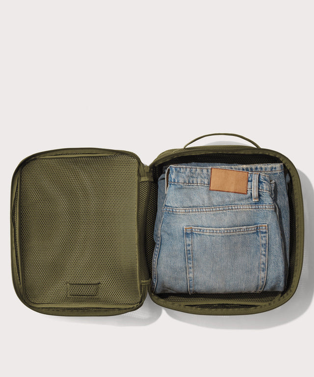 Large Roma packing cube in dark green open with jeans inside