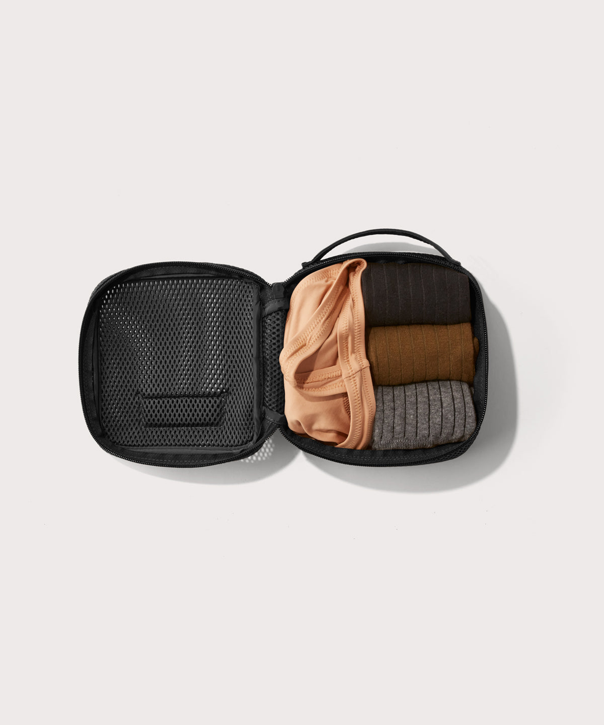 small Roma packing cube in carbon black open with jeans inside
