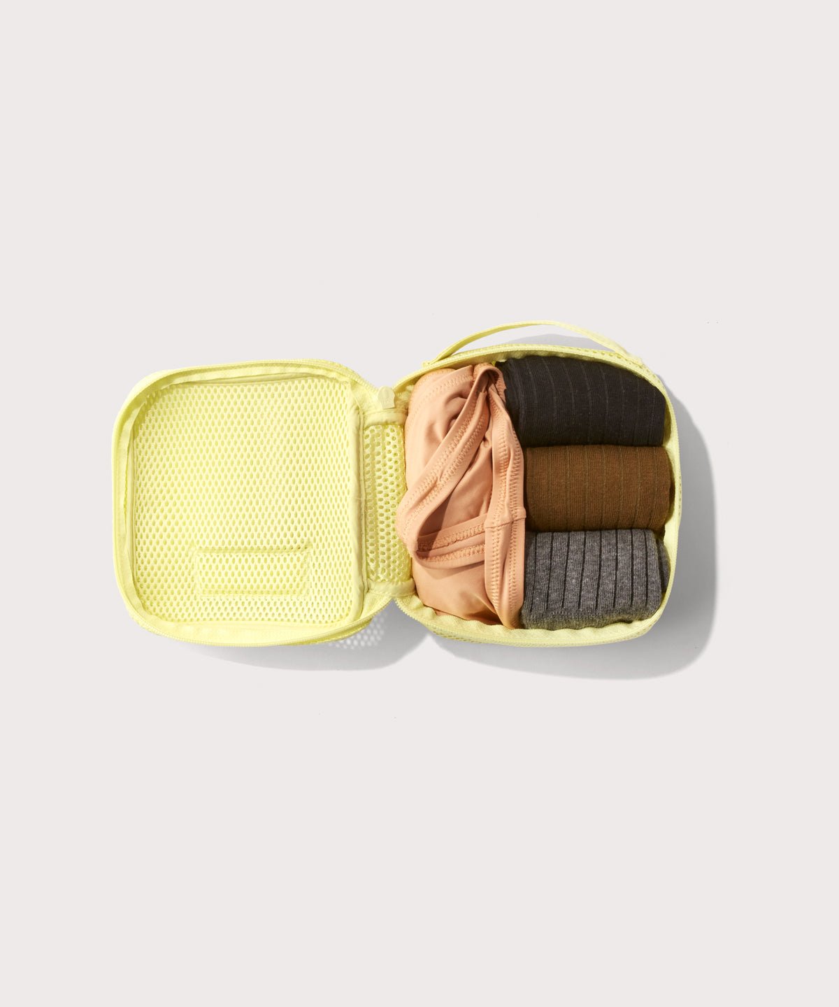 small Roma packing cube in citrine open with jeans inside
