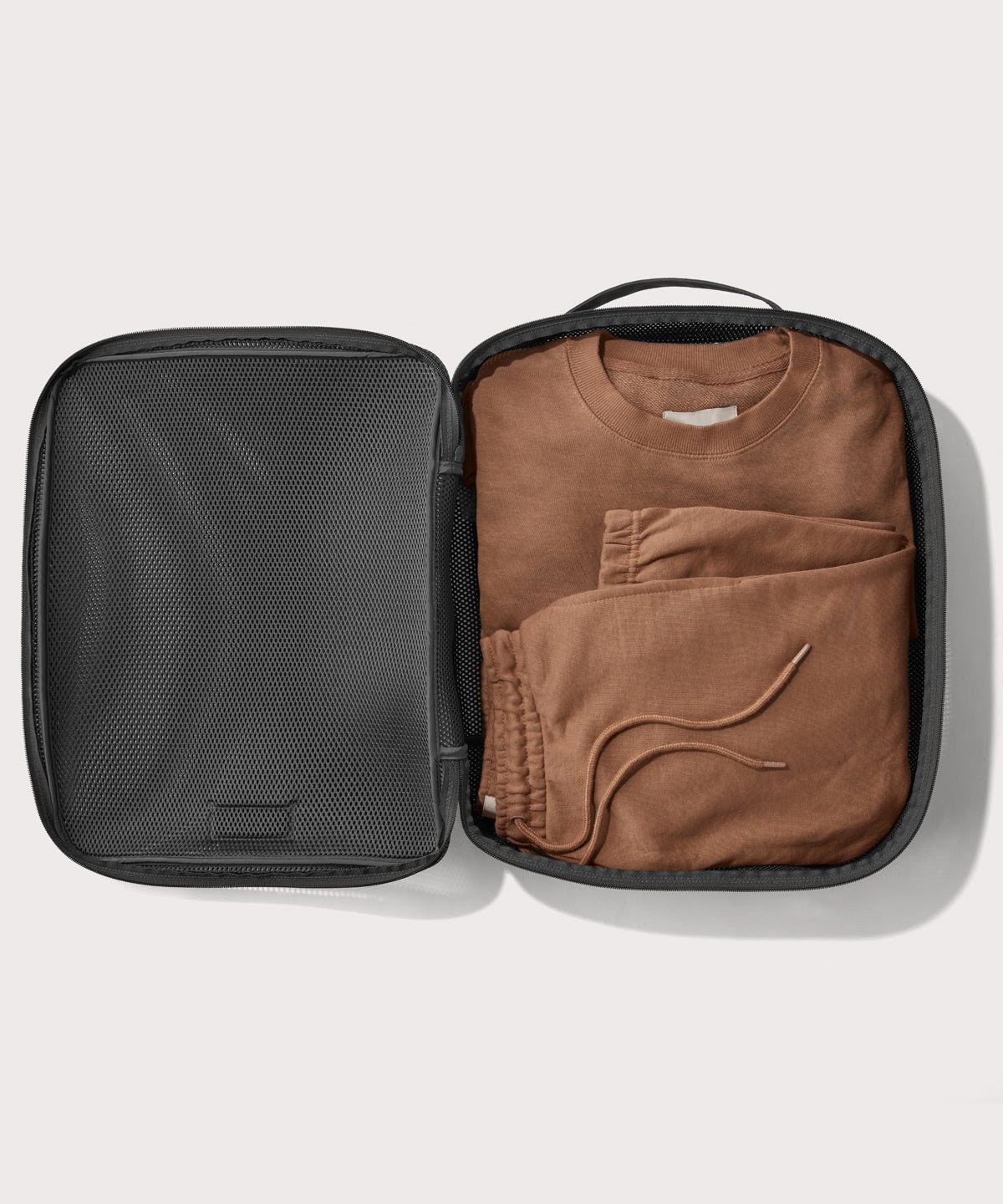 extra large Roma packing cube in carbon black open with sweatsuit inside
