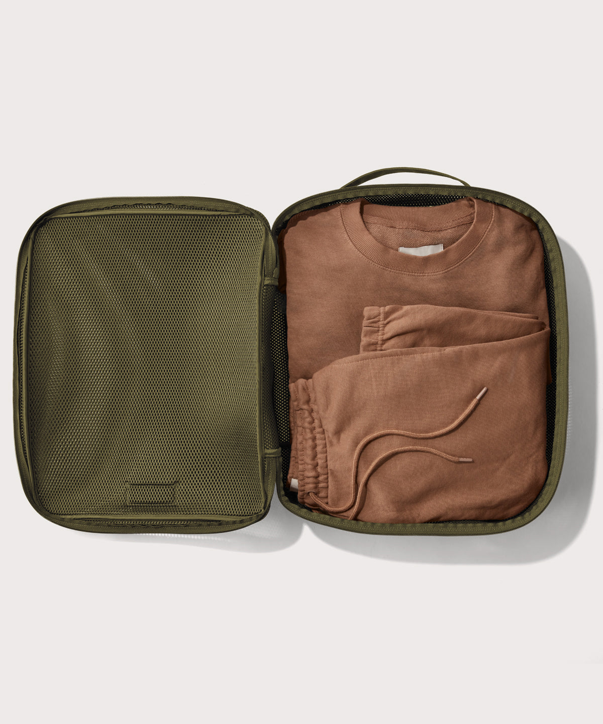 extra large Roma packing cube in dark green open with sweatsuit inside
