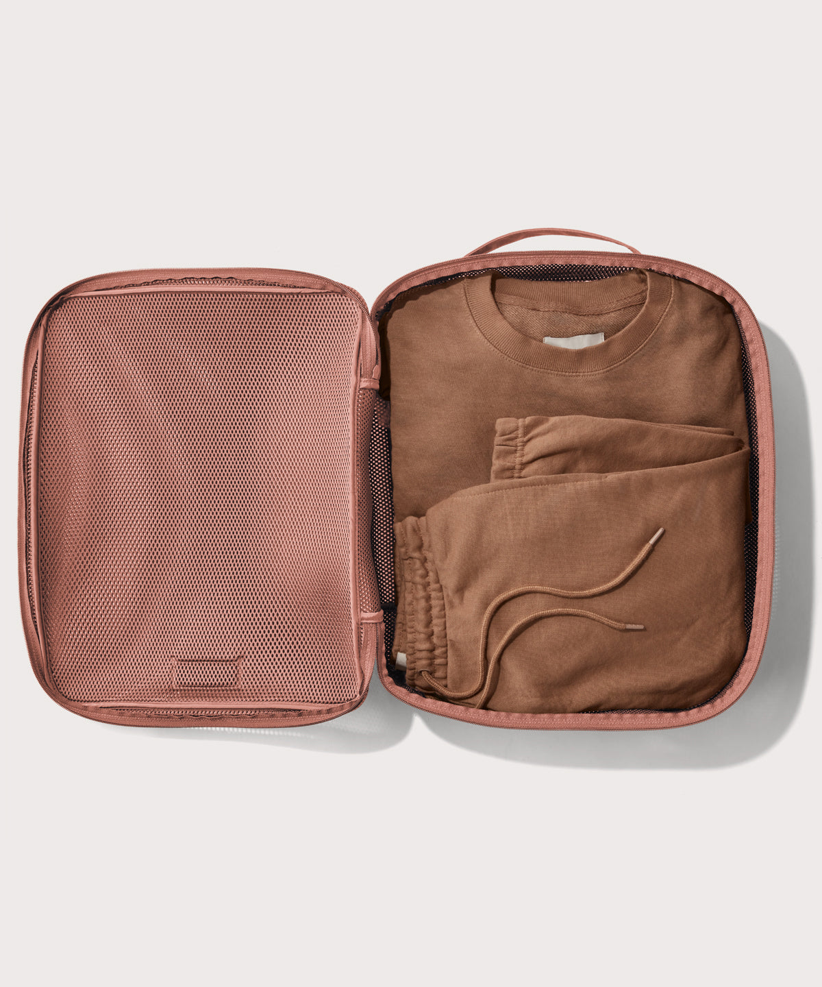 extra large Roma packing cube in warm dust pink open with sweatsuit inside
