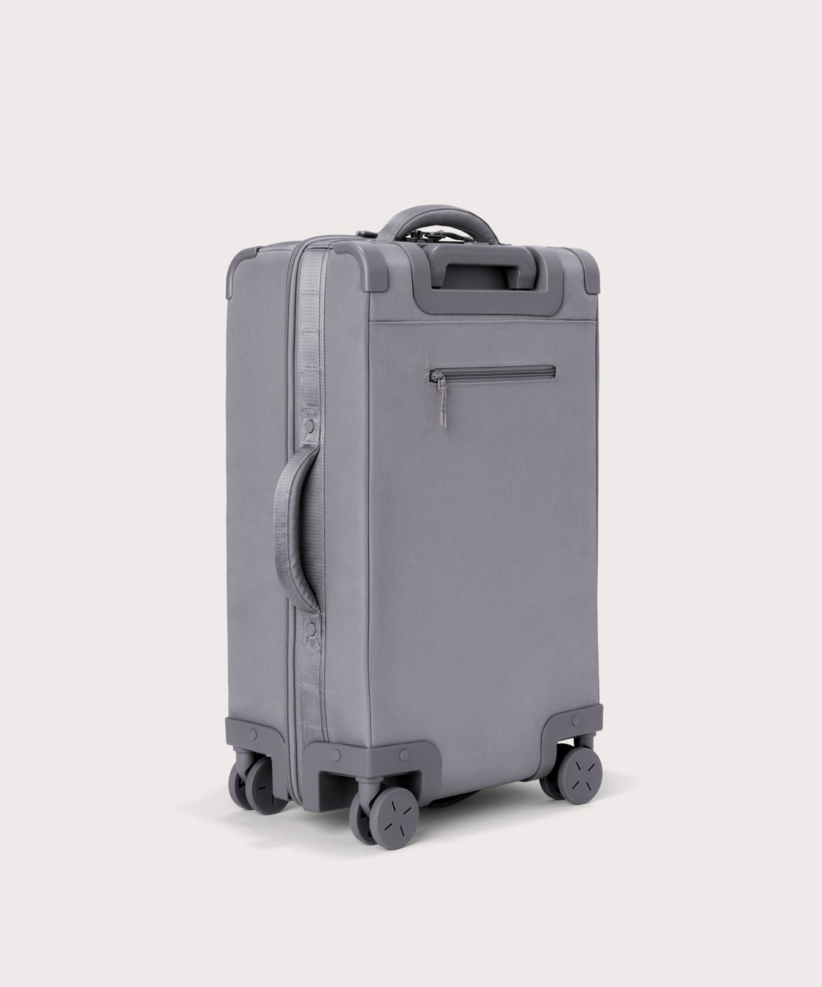 3/4 back view of Seattle carry-on rolling luggage 20.5” in light grey showing side handle and back zippered phone/passport pocket
