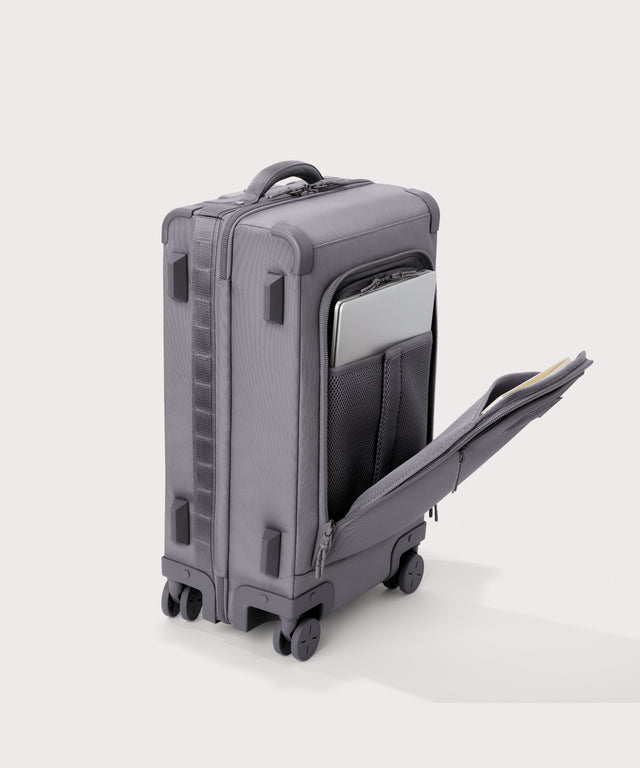 ¾ front view of Seattle carry-on rolling luggage 20.5” in light grey with front flap opened. Caption: Interior slip pocket fits most 13