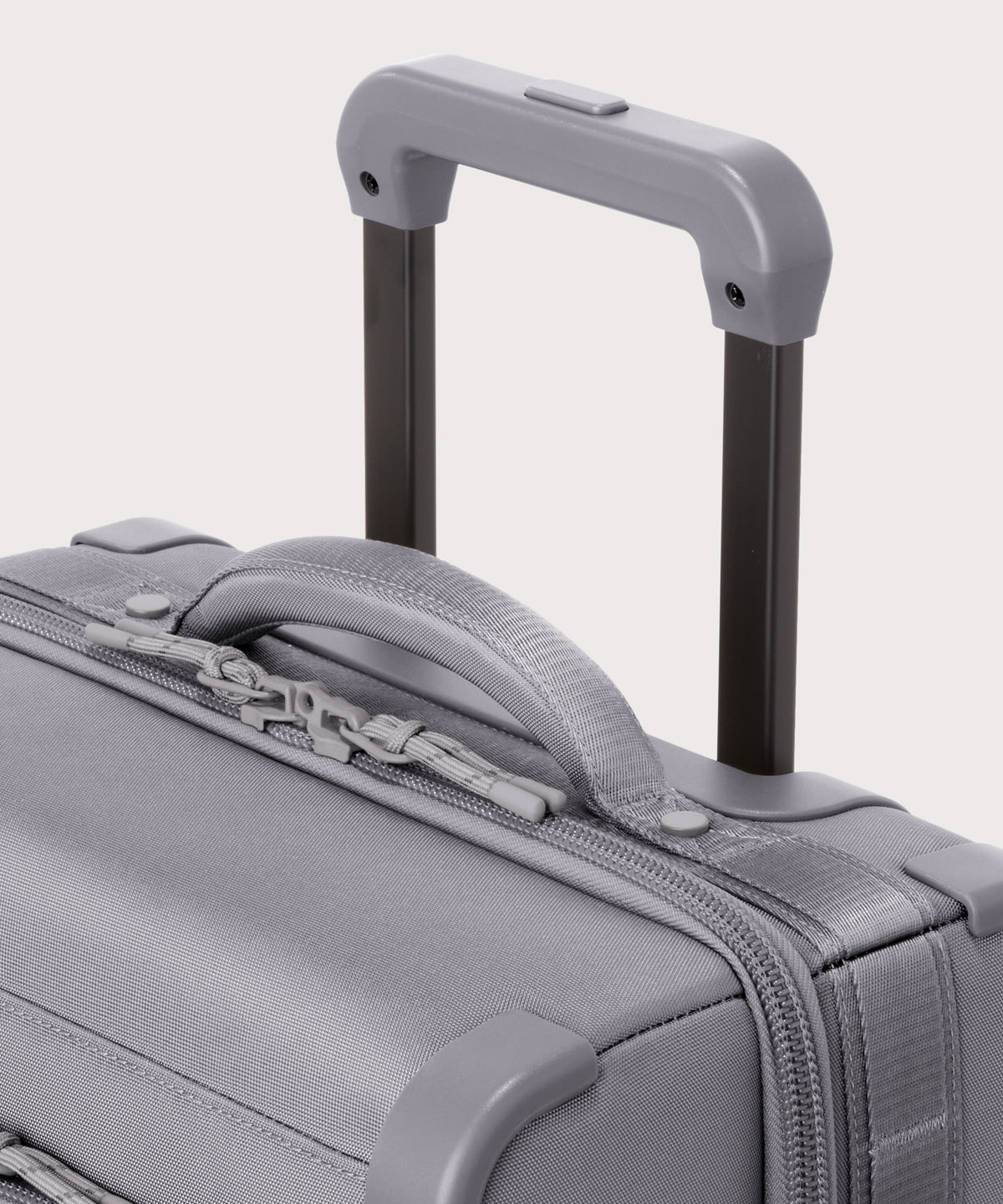 Detail shot of Seattle carry-on rolling luggage 20.5” in light grey extended luggage handle and puffy handle

