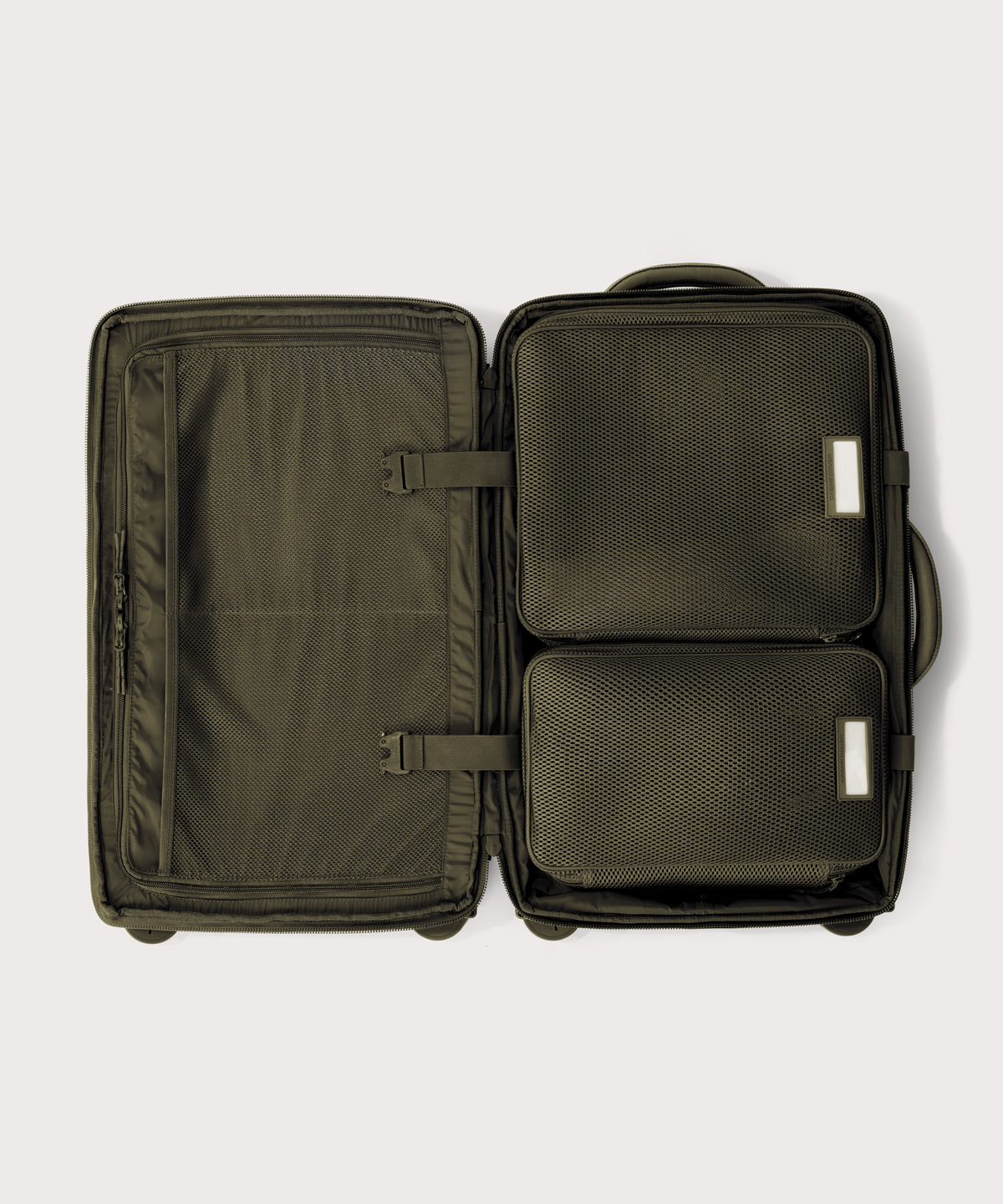 Top down of Seattle carry-on rolling luggage 23.5” in dark moss with interior divider zipped and packing cubes packed into the right side.
