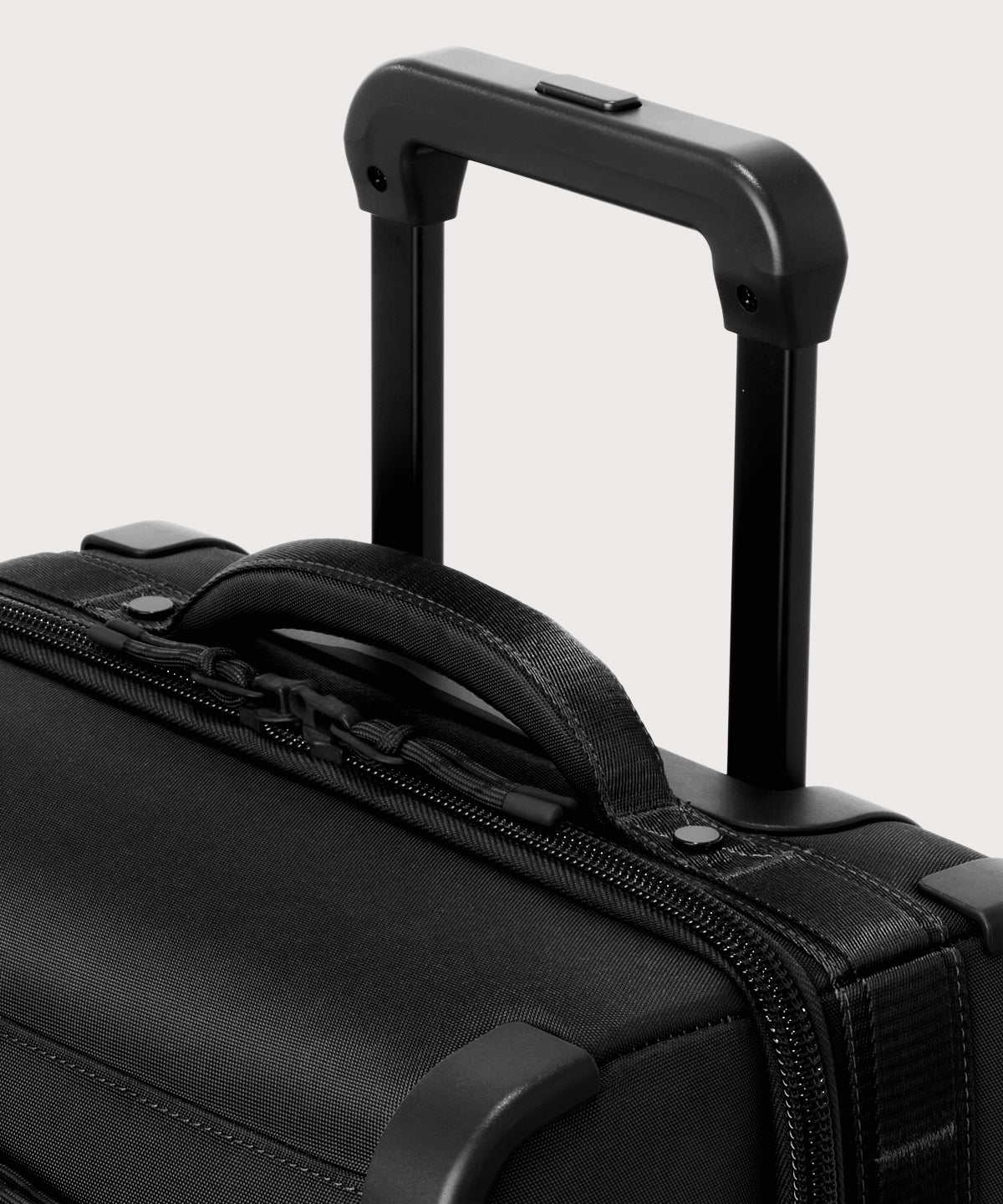 Detail shot of Seattle carry-on rolling luggage 23.5” in onyx extended luggage handle and puffy handle
