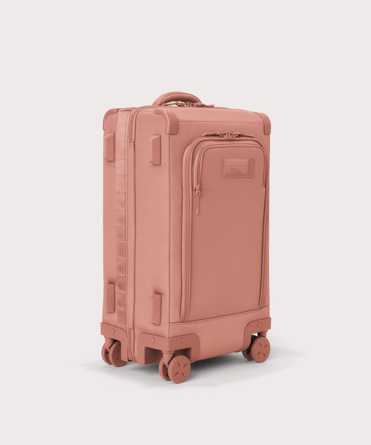 3/4 front view of Seattle carry-on rolling luggage 20.5” in warm dust pink showing side luggage feet
