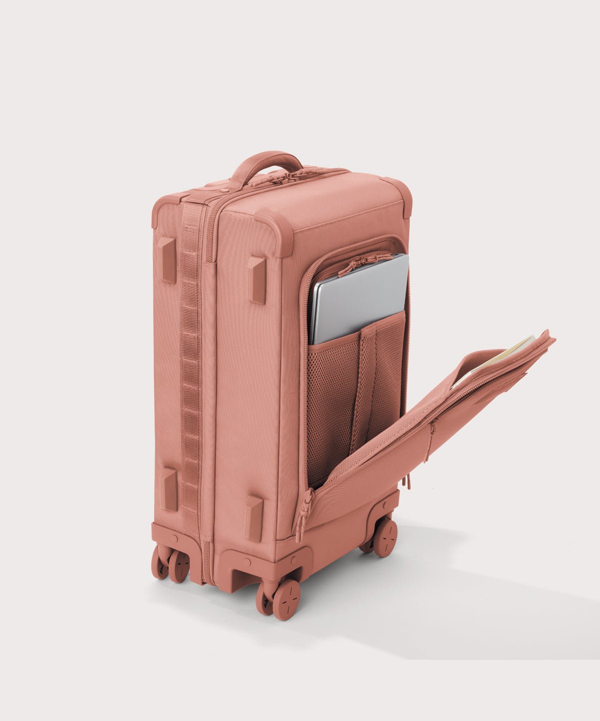 ¾ front view of Seattle carry-on rolling luggage 20.5” in warm dust pink with front flap opened. Caption: Interior slip pocket fits most 13" laptops
