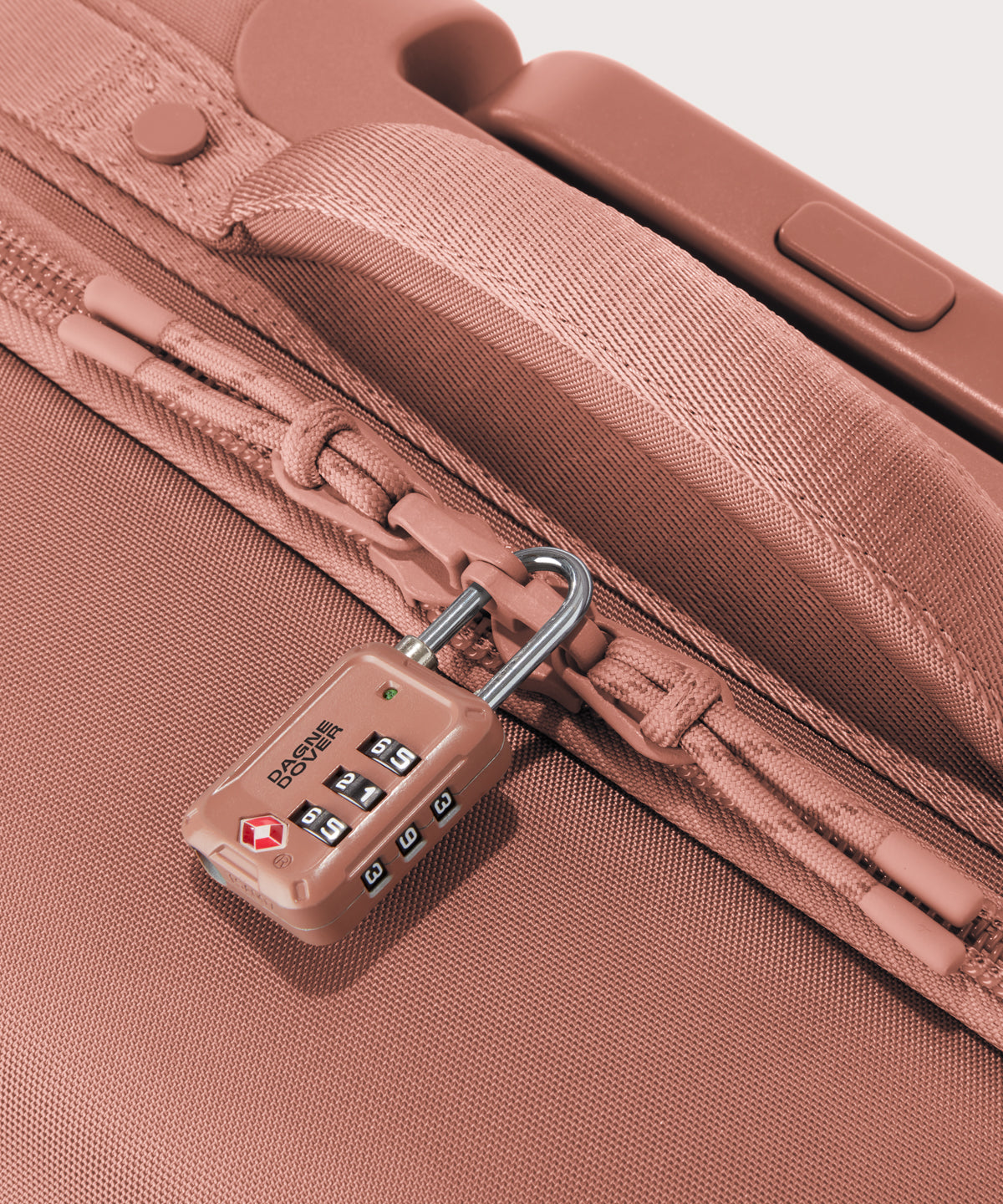 Detail shot of Seattle carry-on rolling luggage 23.5” in warm dust pink lockable zipper heads. Lock not included.