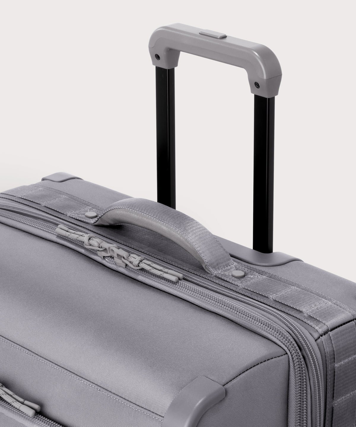 Detail shot of Sydney checked rolling luggage 25" in light grey extended luggage handle and puffy handle