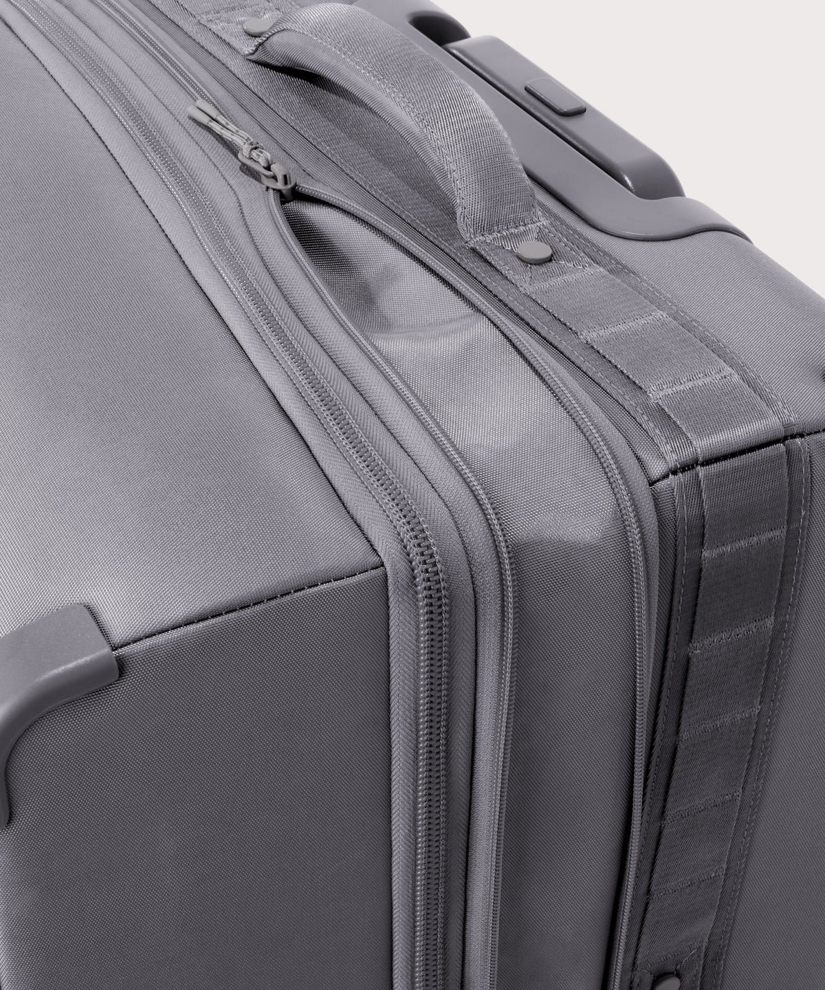 Detail shot of Sydney checked rolling luggage 25" in light grey expandable zipper feature
