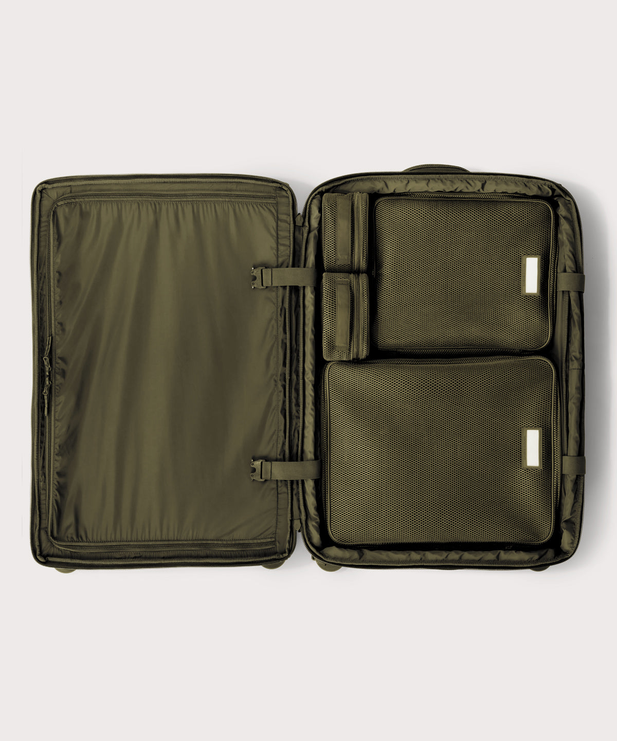 Top down of Sydney checked rolling luggage 28.5” in dark green with interior divider zipped and packing cubes packed into the right side. 
