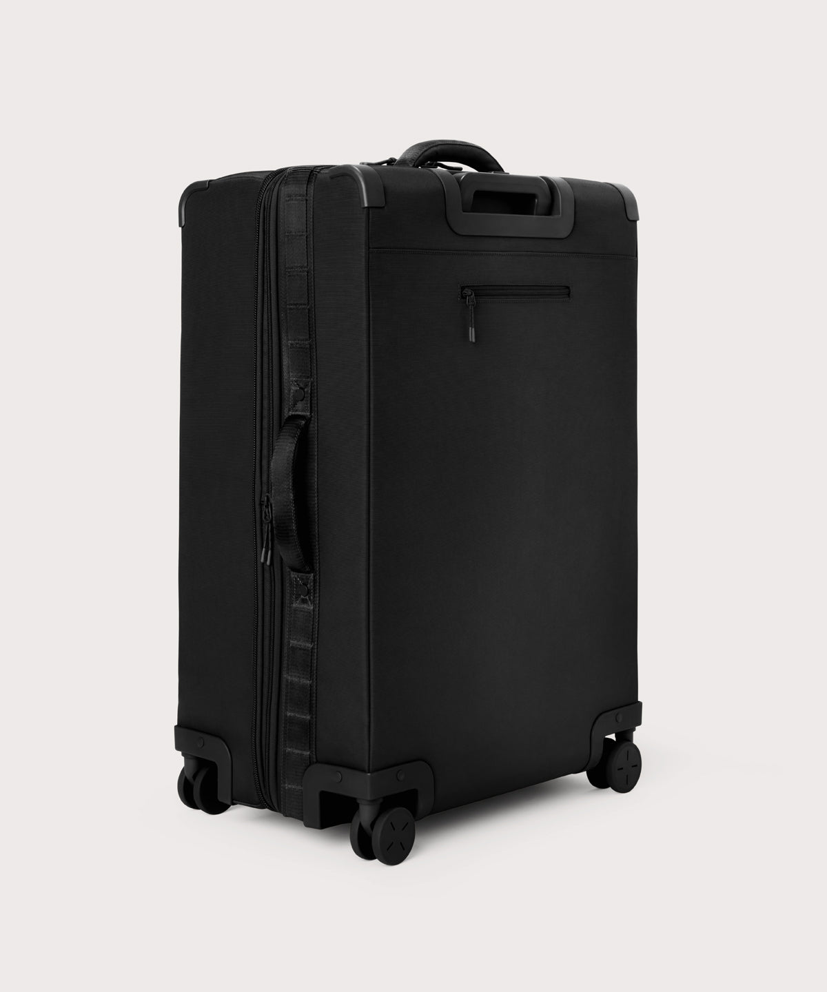 3/4 back view of Sydney checked rolling luggage 28.5” in onyx showing side handle and back zippered phone/passport pocket
