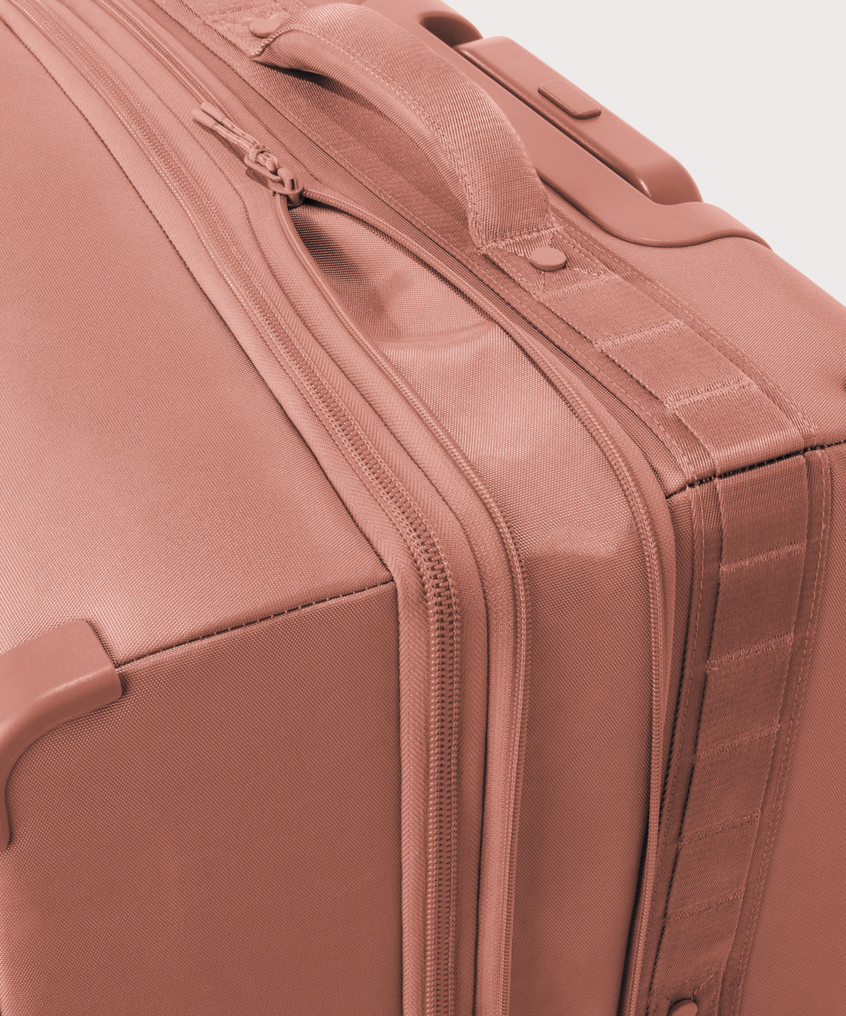 Detail shot of Sydney checked rolling luggage 25" in warm dust pink lockable zipper heads. Lock not included. 
