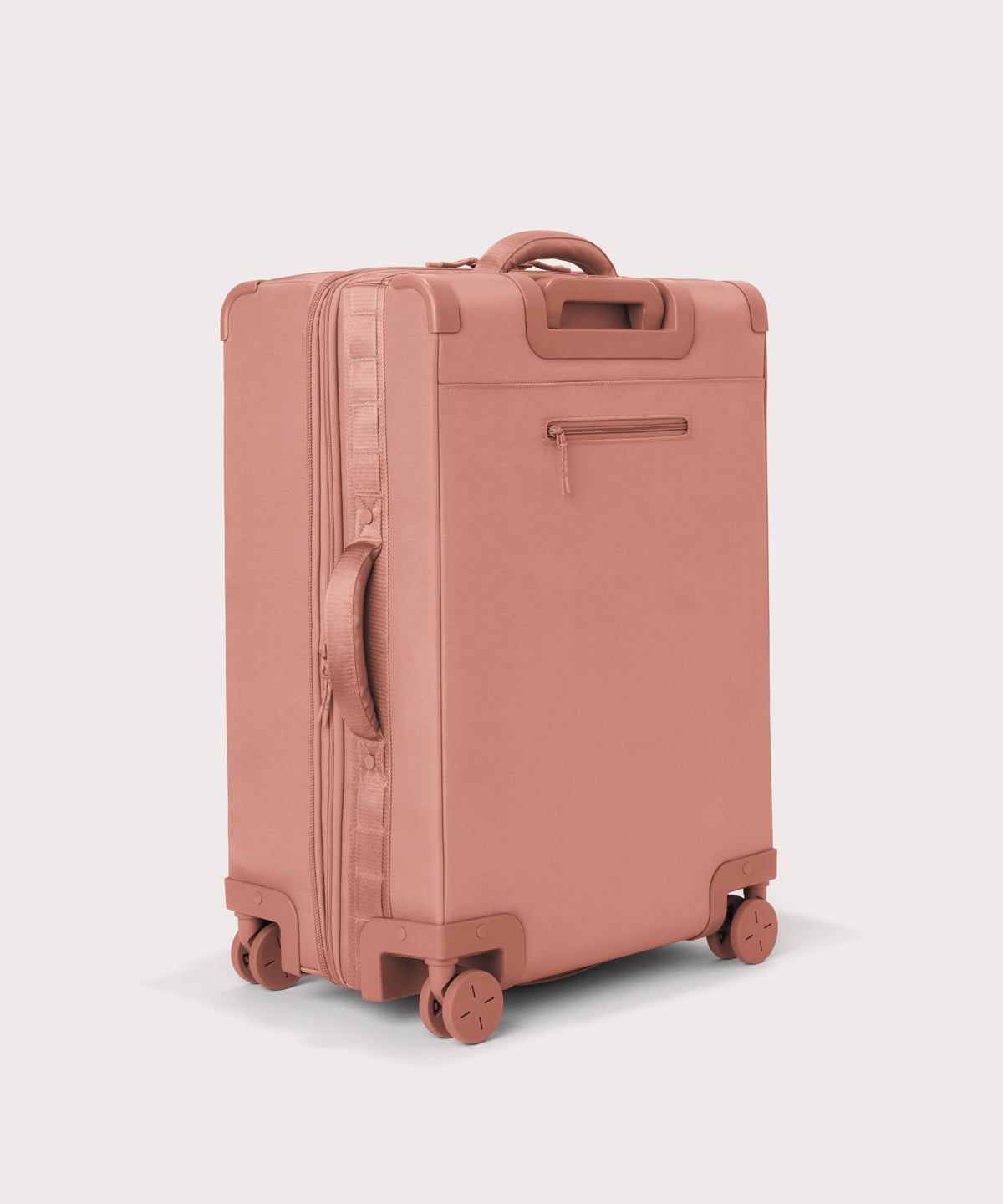 3/4 back view of Sydney checked rolling luggage 25" in warm dust pink showing side handle and back zippered phone/passport pocket
