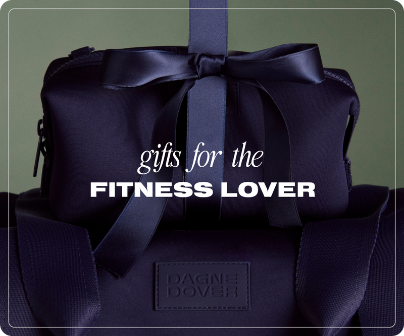 Navy blue bag with a bow and 'Dagne Dover' branding, with text 'Gifts for the Fitness Lover' on a dark green background.