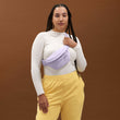 A woman wearing the Ace Fanny Pack in light purple as a crossbody bag. 