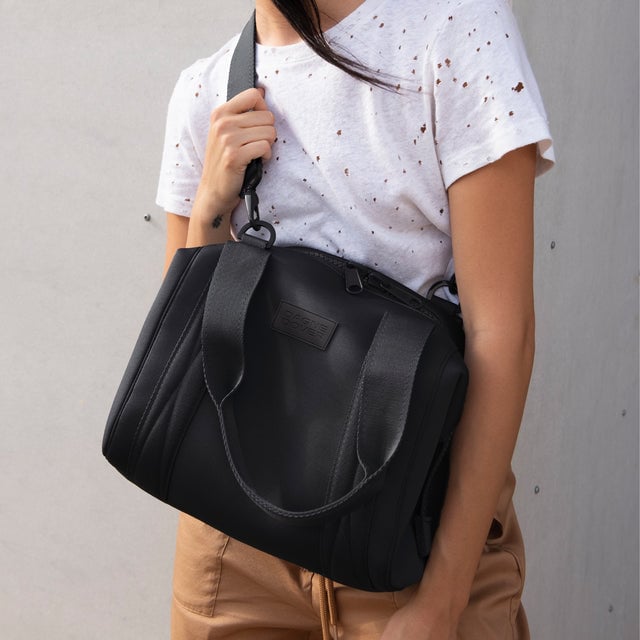 Small Landon Carryall in black being used as a crossbody bag editorial image